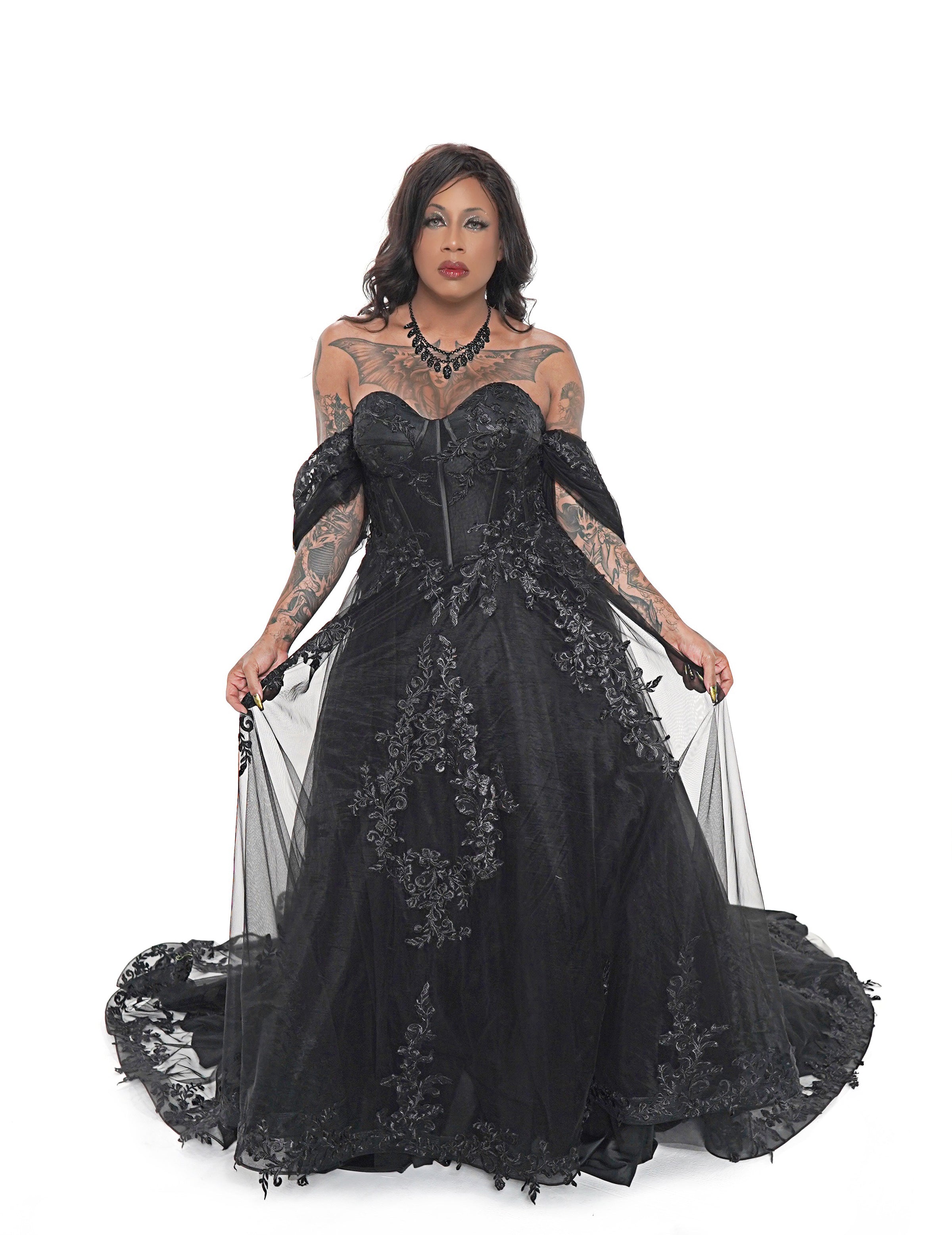 Black gothic wedding dress by Bête Noire with corset bodice, off shoulder sleeves, and lace appliqué skirt