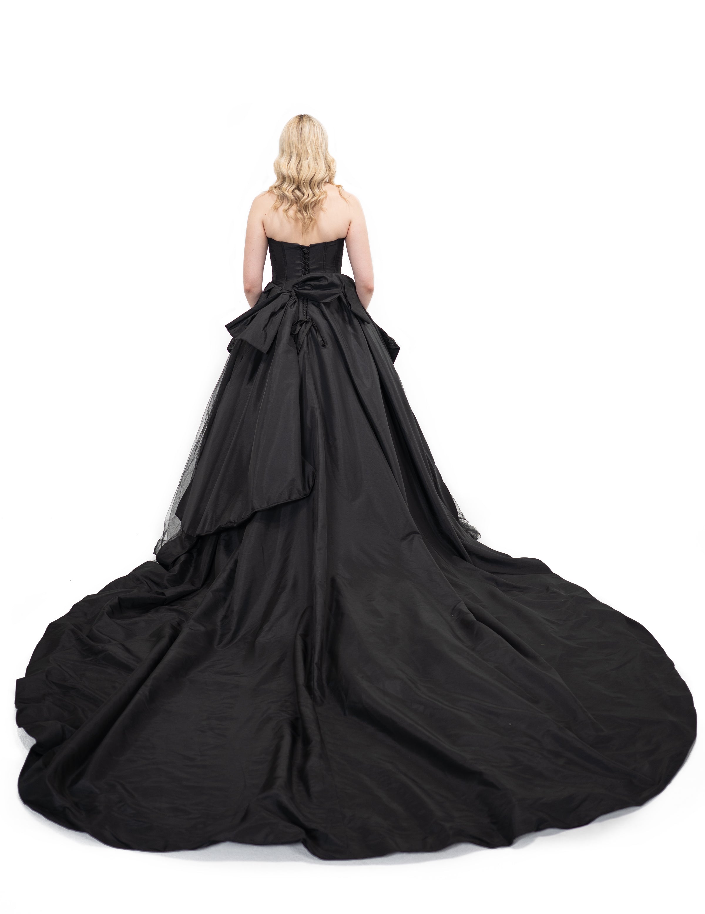 Back view of black gothic wedding dress with corset closure and oversized bow detail by Bête Noire