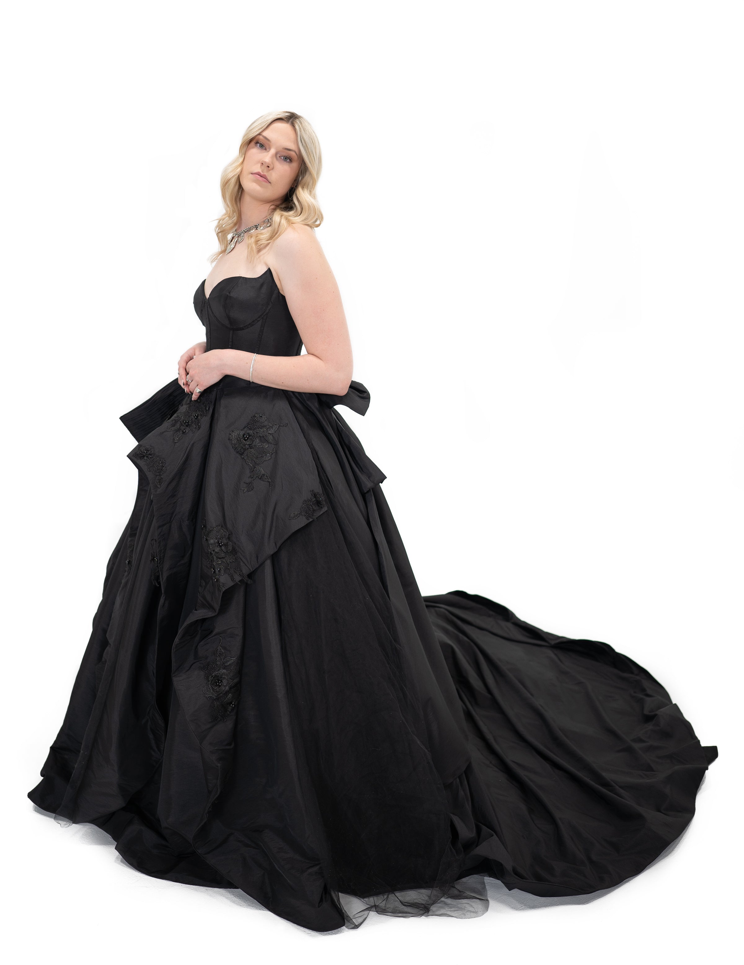 Alternative black bridal gown with voluminous skirt and dramatic train, angled side view by Bête Noire