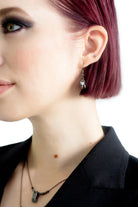 Extraction tooth earrings styled with alternative gothic outfit