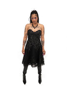 Front view of Bête Noire Nyx dress, a black strapless gothic lace dress with structured bodice and flared skirt