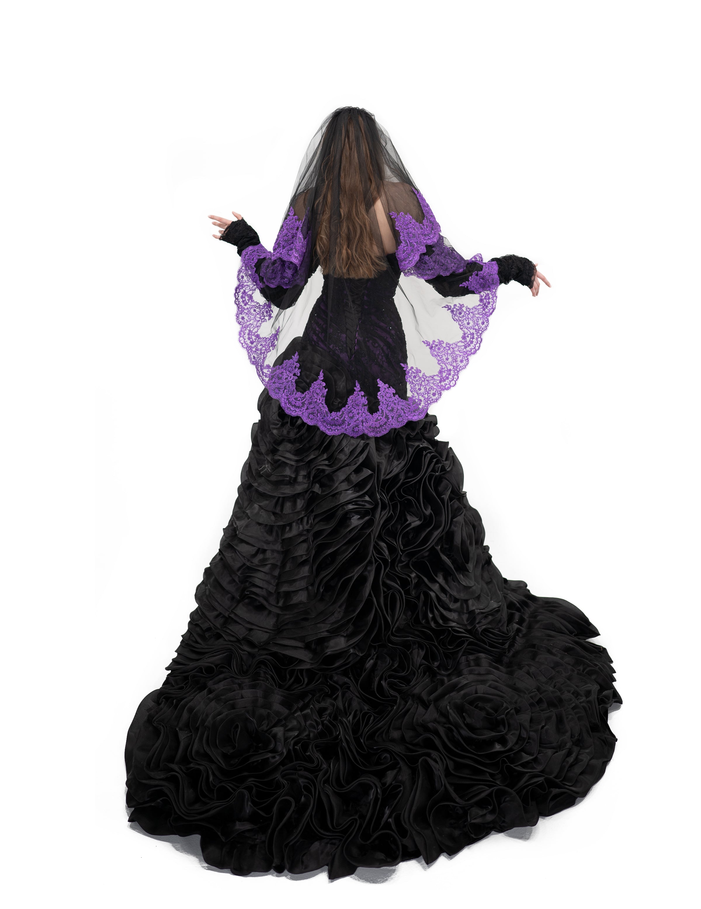 Oath veil by Bête Noire draped over the face in black tulle with dark purple lace for a gothic bridal look