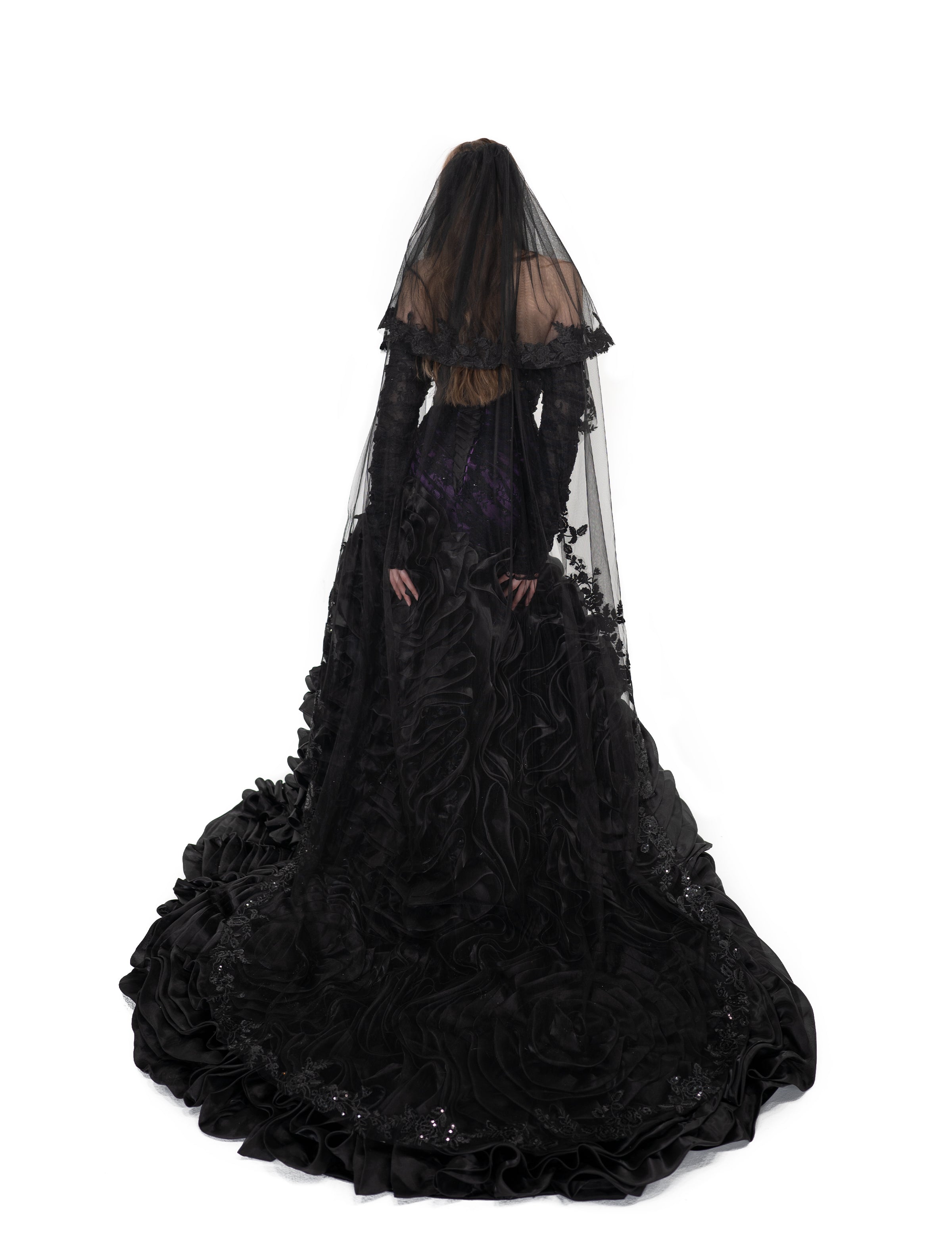 Back view of the Raven Veil by Bête Noire, a long black two-tier veil with lace details cascading down the gown