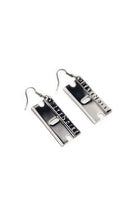 Close up of gunmetal razor blade earrings by Bête Noire