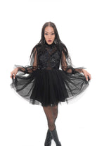 Close-up of Vixen dress featuring sheer black bodice with floral appliqué and high neckline