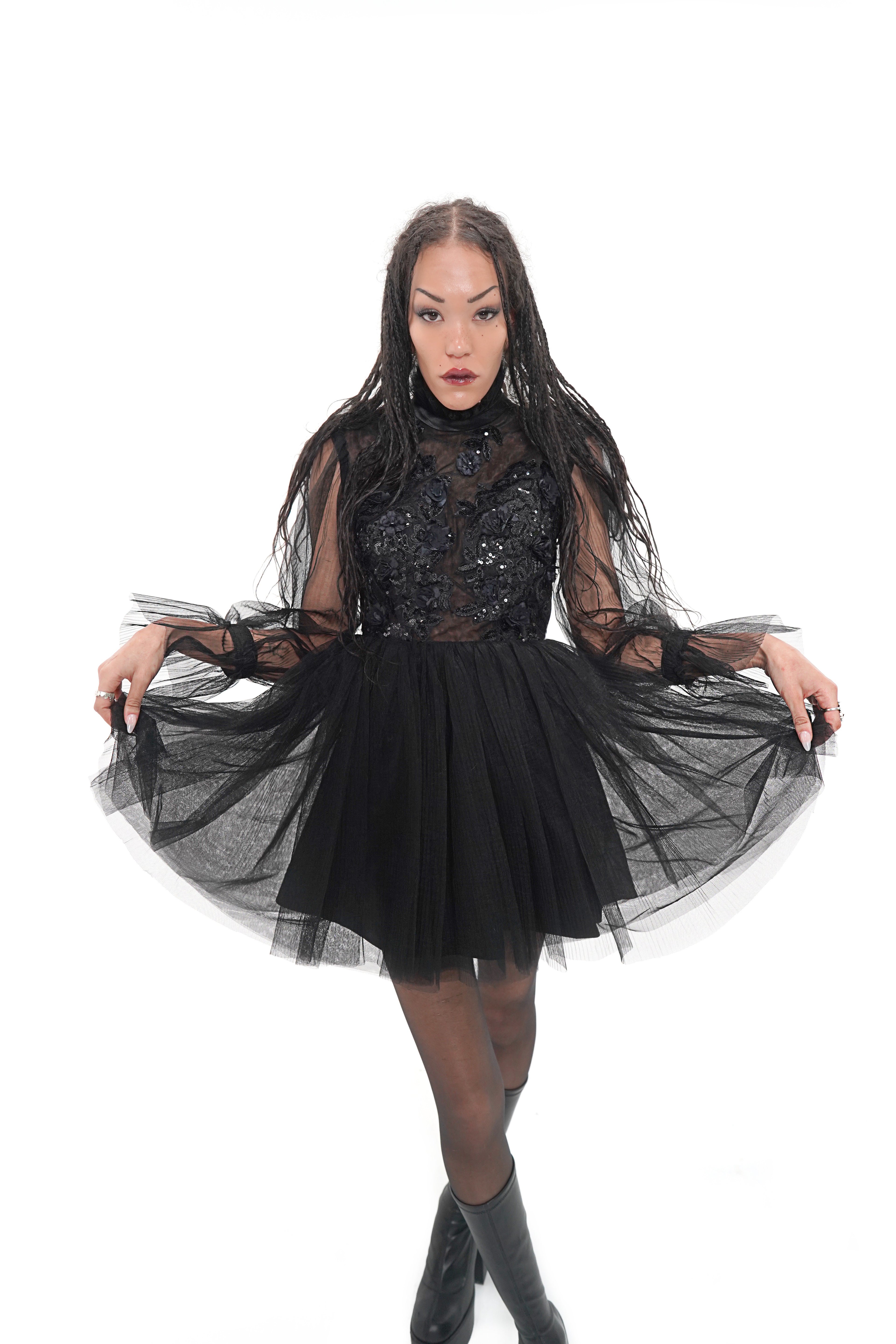 Close-up of Vixen dress featuring sheer black bodice with floral appliqué and high neckline