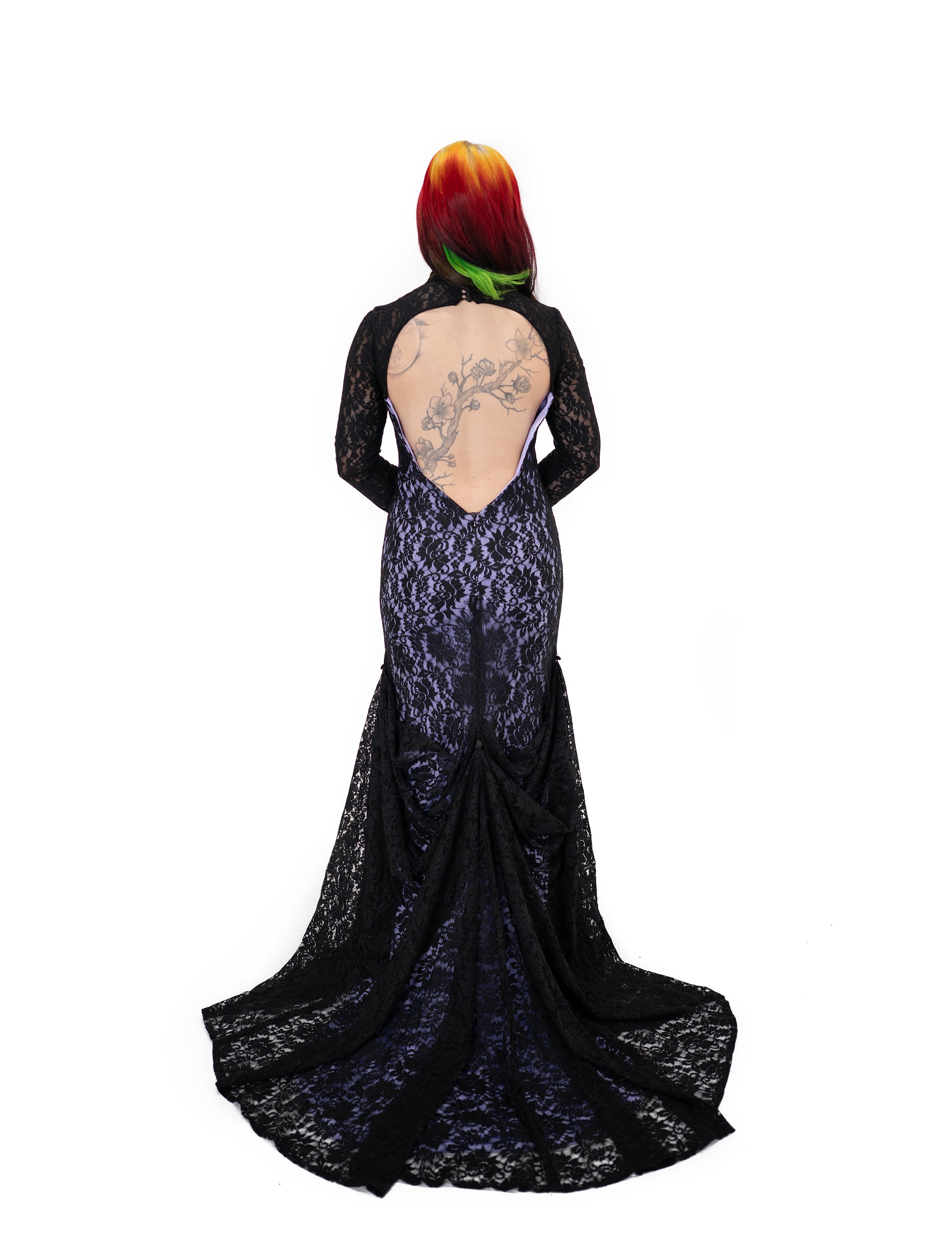 Back view of the Evangeline gown by Bête Noire showing the black lace train bustled over a purple underlay