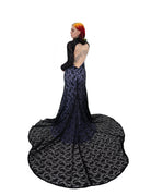Back view of the Evangeline gown by Bête Noire with an open back and long black lace train over a purple underlay