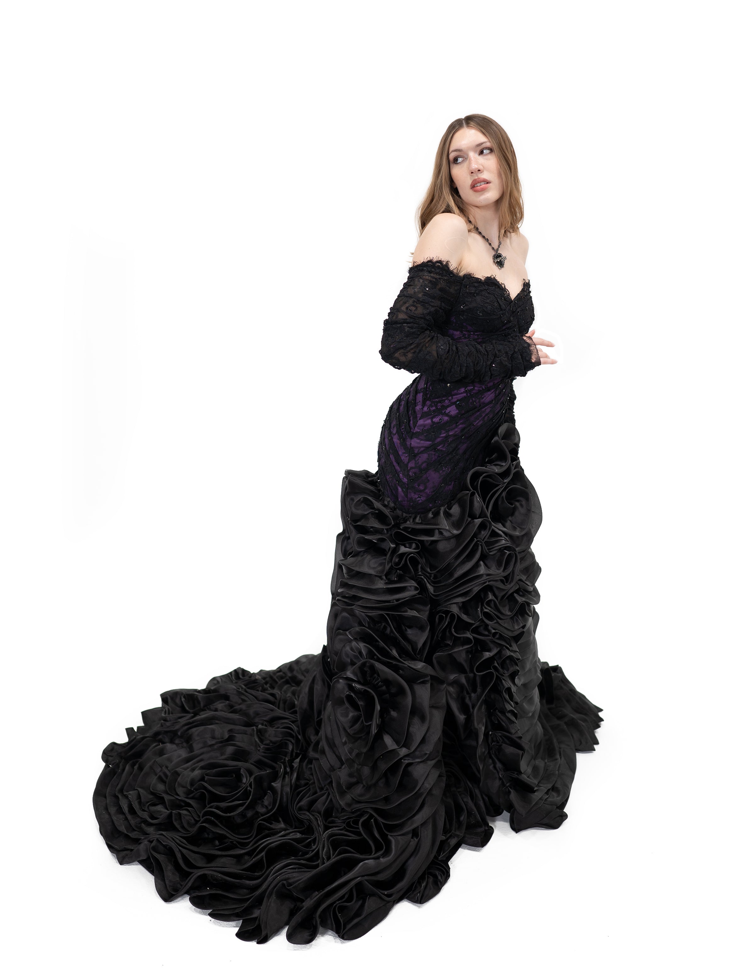 Alternative bridal black and purple gown with fitted bodice and voluminous ruffled train from side view
