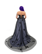 Back view of a black and purple alternative bridal gown with a corset lace-up back and long sheer tulle train.