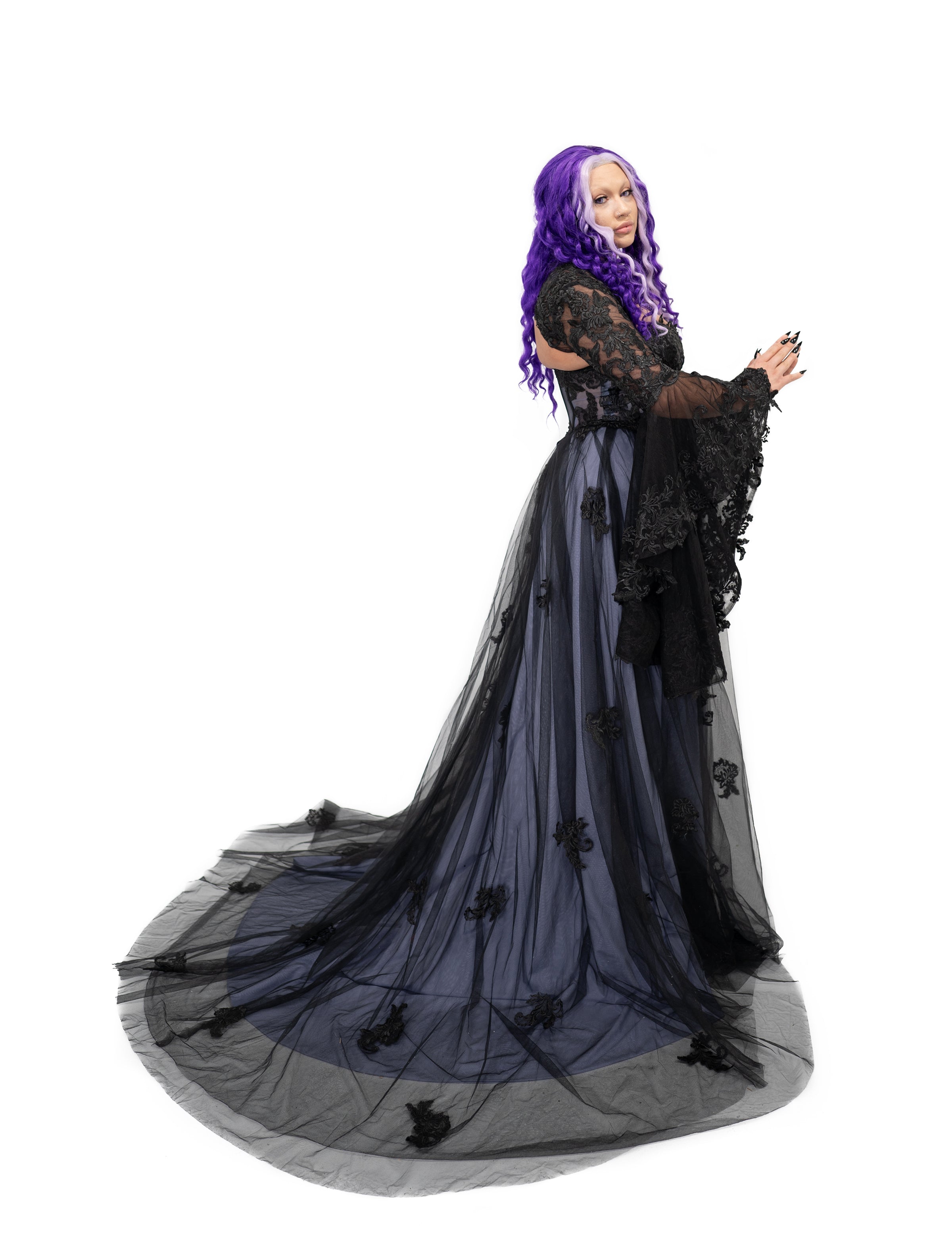 Side view of a black and soft purple tulle gothic wedding dress with a fitted corset bodice and full flowing skirt.